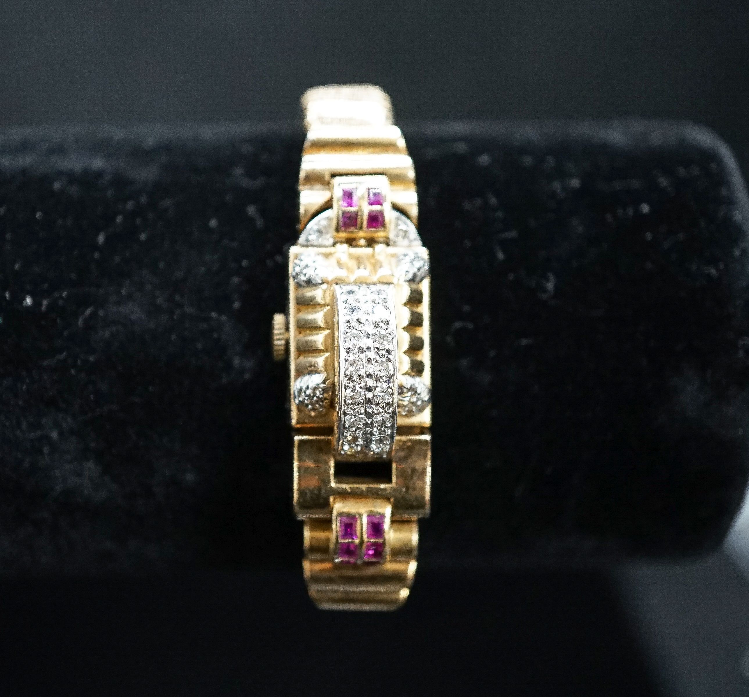 A 1950's 9ct gold, ruby and diamond set Emka manual wind cocktail watch, the dial with gem set hinged cover, gross weight 37.2 grams.